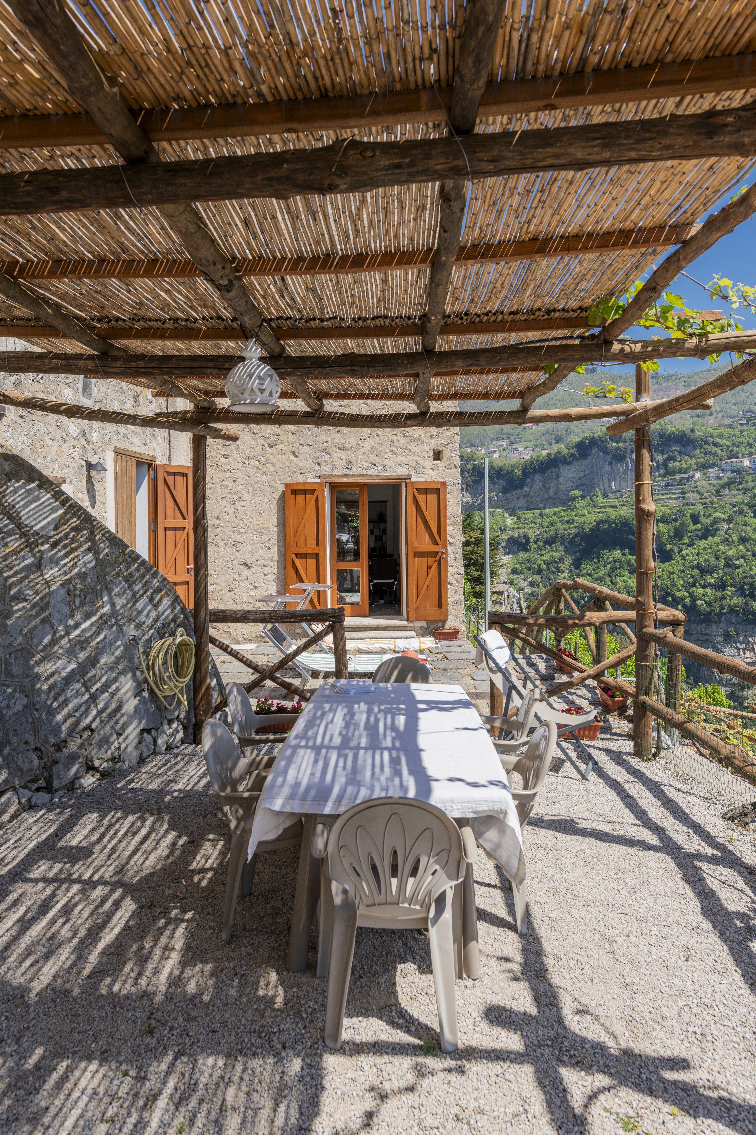 Foto: terrazza all'ora d'oro, pergolato di viti e mare sullo sfondo